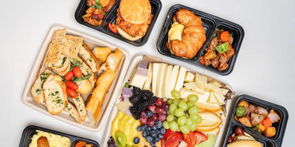 A charcuterie board with various fruits, breads, meats, and cheeses.