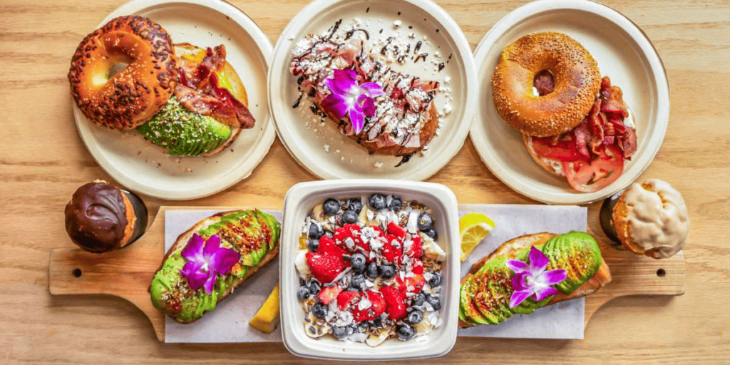 A breakfast spread of bagels, yogurt, and avocado toast.